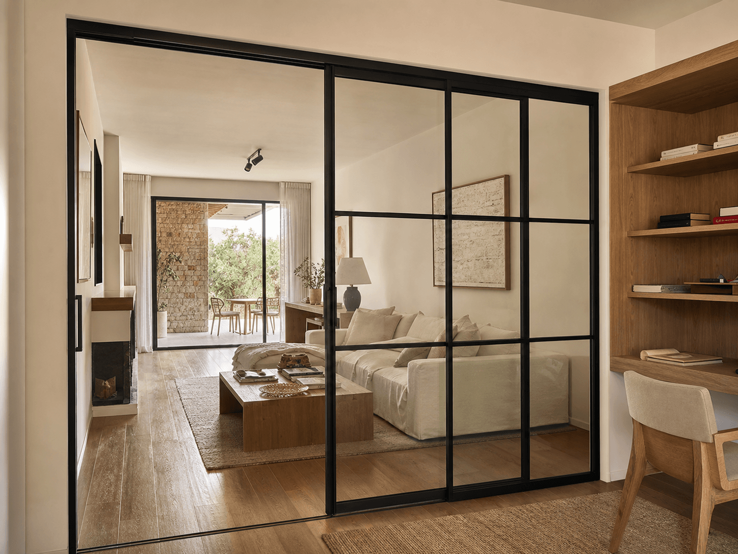 Divisorio de ambiente de acero negro y vidrio transparente entre living y cocina