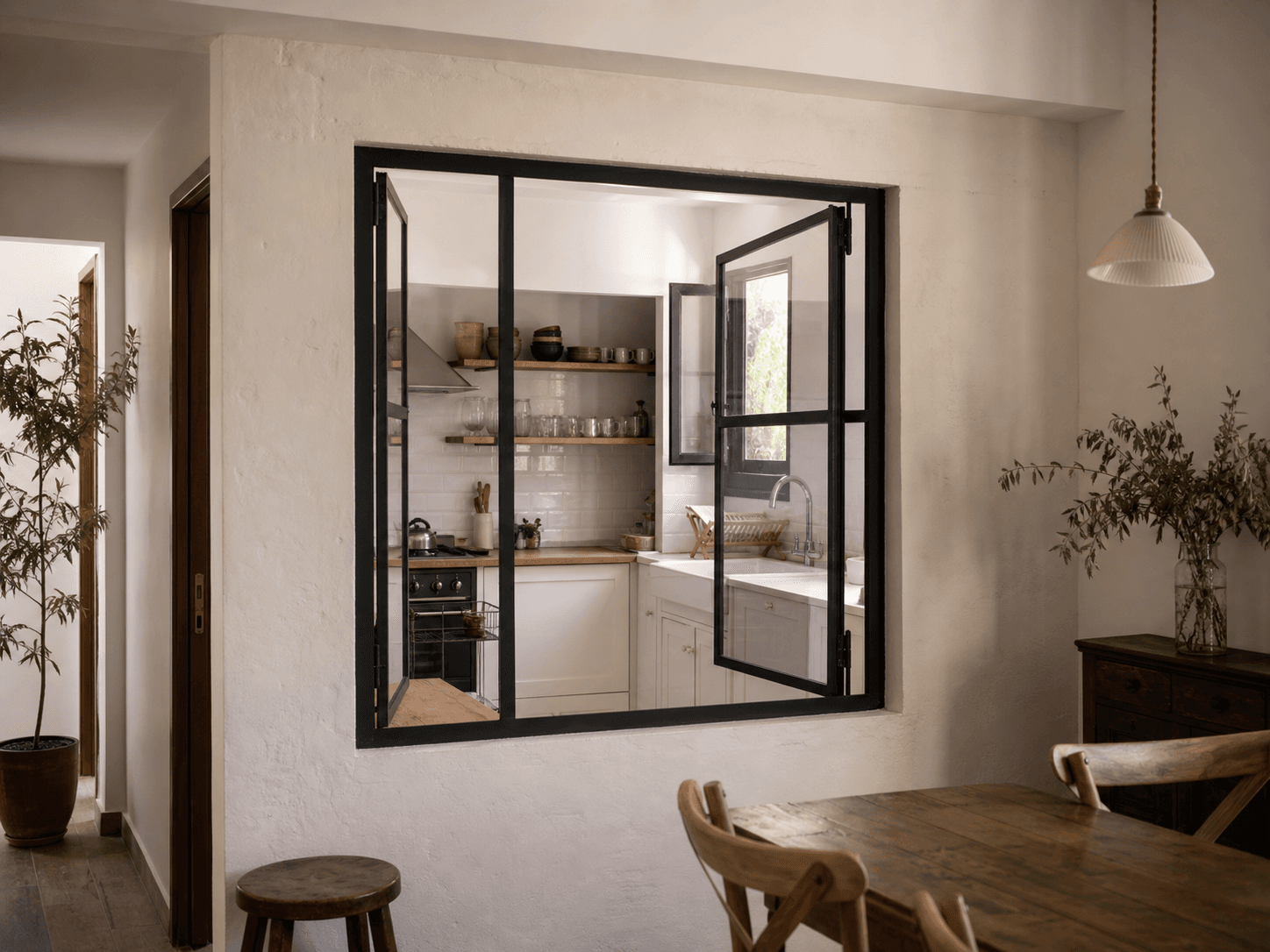 Ventana interior de hierro y vidrio que comunica cocina y comedor